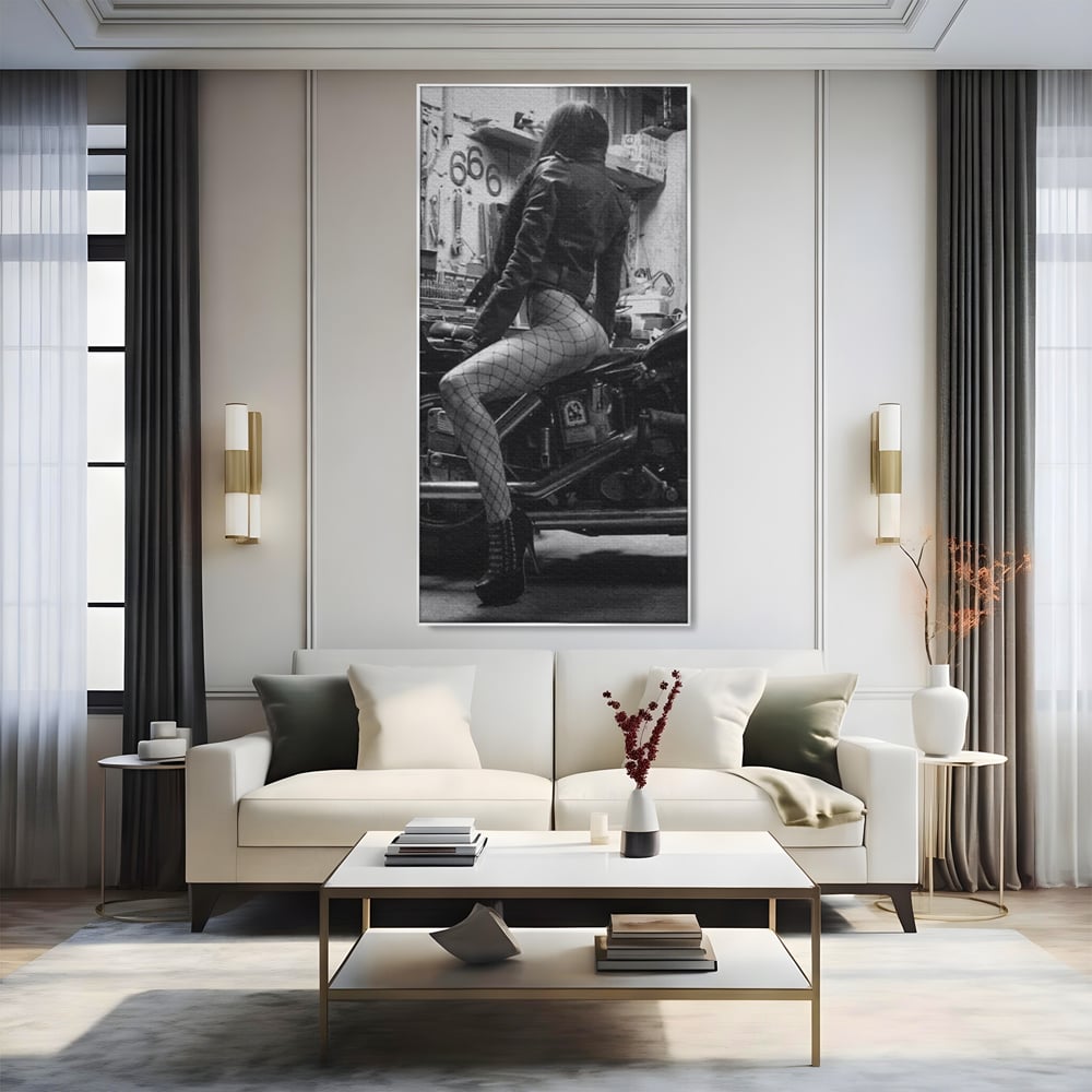 Tablou canvas cu tablou canvas cu femeie pe motocicleta, in rama de aluminiu argintiu, pe perete intr-un living